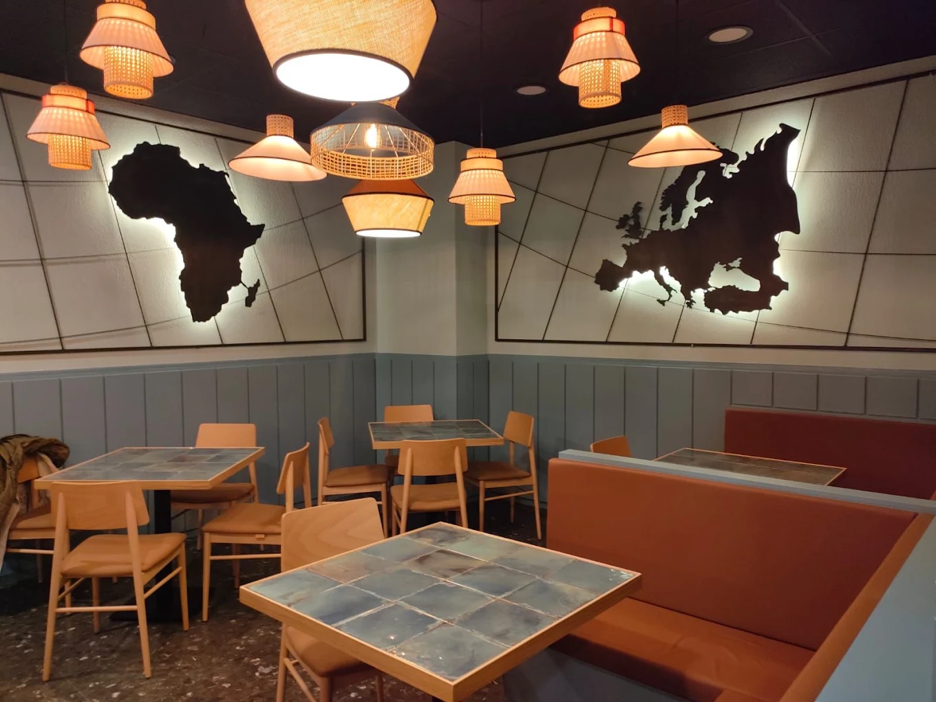 Interior de Nuevo Bar Atlas en Vigo con iluminación cálida y mapas en las paredes